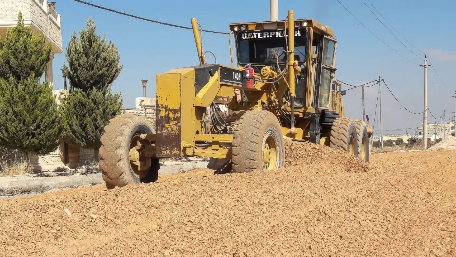 Road grader preparing a base course layer