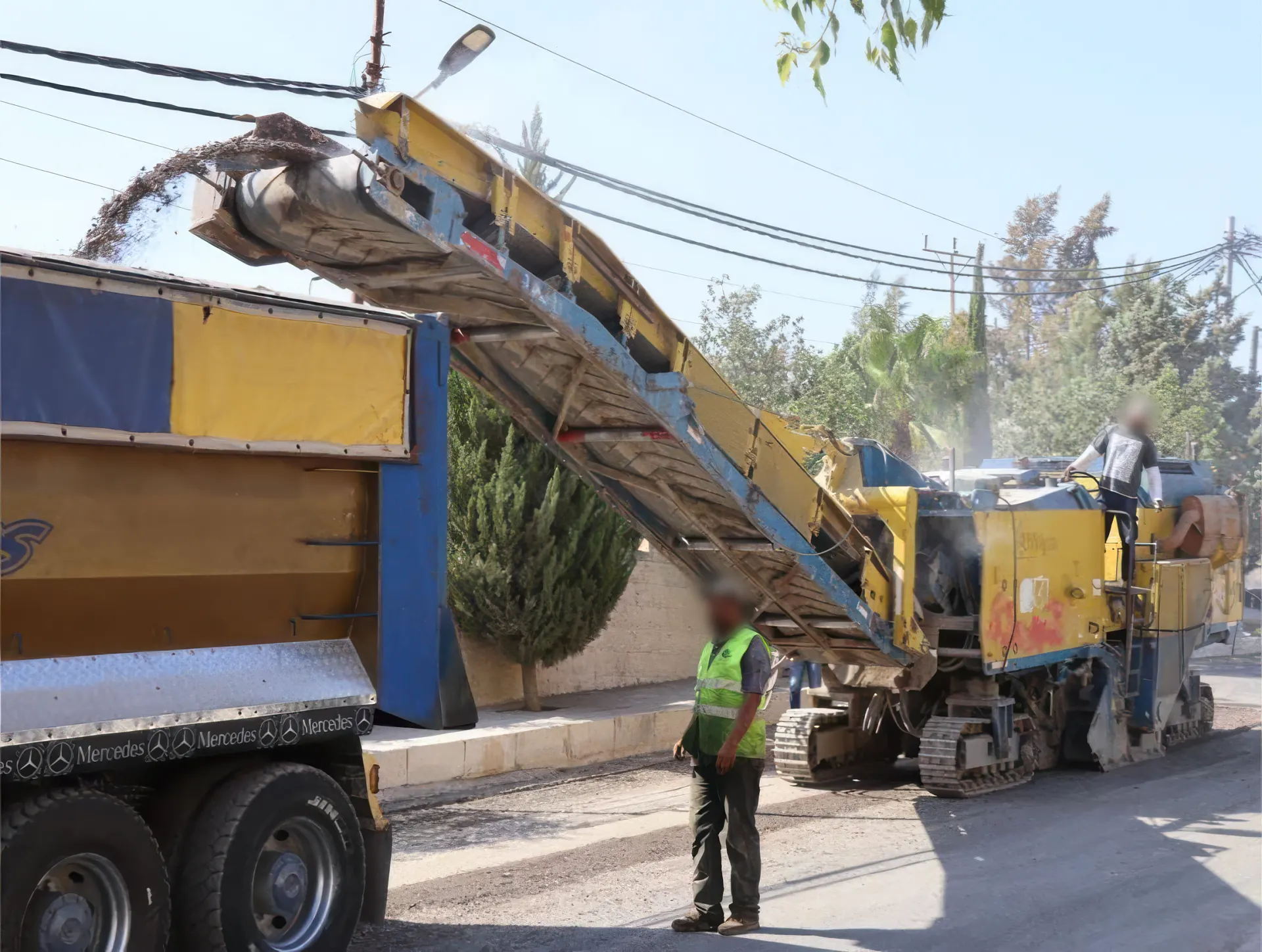 Milling machine loading reclaimed asphalt onto a truck